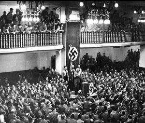 Hitler speaking in Munich to an assembly of old Nazi comrades, on anniversary of his failed "Beer-Hall putsch". 1 year ago today, he was almost blown up by a bomb from a German assassin.