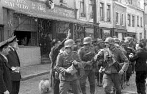 Ethnic Germans living in Malmedy welcome Wehrmacht invaders with pints of beer- Hitler has returned territories annexed by Belgium under Treaty of Versailles to the German Reich.