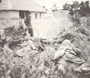 Italian troops in hastily-dug trenches near Albanian border desperately resisting Greek advance- hope to buy time for evacuation of Italian headquarters from Korçë.