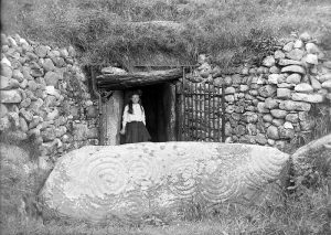 The entrance to Newgrange in the early 1900s, after much of the debris had been cleared. Newgrange is the best known Irish passage tomb and dates to c.3,200BC. The large mound is approximately 80m in diameter and is surrounded at its base by a kerb of 97 stones. The most impressive of these stones is the highly decorated Entrance Stone.