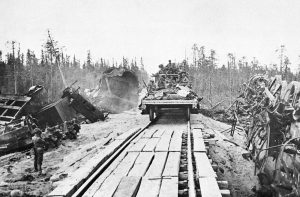 A Finnish troop train passes through a scene of an earlier explosion which wrecked one train, tearing up the rails and embankment, on October 19, 1941.