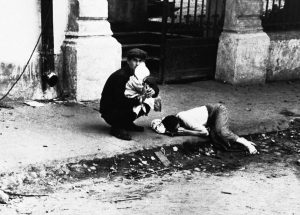A man, his wife, and child are seen after they had left Minsk on August 9, 1941, when the German army swarmed in. The original wartime caption reads, in part: “Hatred for the Nazis burns in the man’s eyes as he holds his little child, while his wife, completely exhausted, lies on the pavement”.
