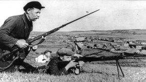 Rapidly advancing German forces encountered serious guerrilla resistance behind their front lines. Here, four guerrillas with fixed bayonets and a small machine gun are seen in action, near a small village.