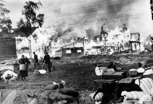 Russian men and women rescue their humble belongings from their burning homes, said to have been set on fire by the Russians, part of a scorched-earth policy, in a Leningrad suburb on October 21, 1941.