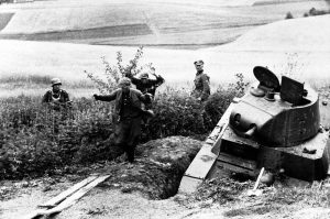 Russian snipers leave their hide-out in a wheat field, somewhere in Russia, on August 27, 1941, watched by German soldiers. In foreground is a disabled soviet tank.