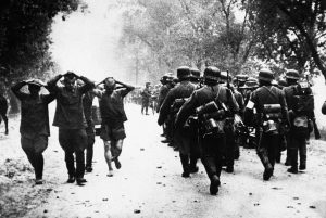 Russian soldiers, left, hands clasped to heads, marched back to the rear of the German lines on July 2, 1941, as a column of Nazi troops move up to the front at the start of hostilities between Germany and Russia.