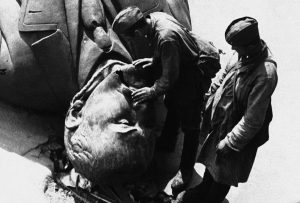 Two Russian soldiers, now prisoners of war, inspect a giant statue of Lenin, somewhere in Russia, torn from its pedestal and smashed by the Germans in their advance, on August 9, 1941. Note the rope round the neck of the statue, left there in symbolic fashion by the Germans.